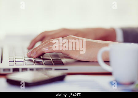 Frau Hand Tippen auf ihrem Laptop im Büro Stockfoto