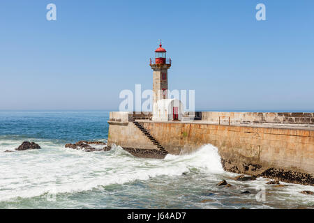 Porto, Portugal - Wellen, die gegen die Felgueiras Leuchtturm und Mole in Foz do Douro Stockfoto