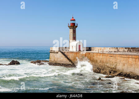 Porto, Portugal - Wellen, die gegen die Felgueiras Leuchtturm und Mole in Foz do Douro Stockfoto