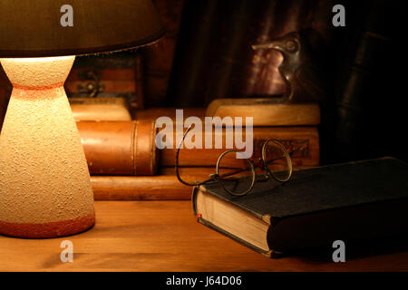 Vintage Stillleben mit der alten Brille Buch in der Nähe von Schreibtischlampe Stockfoto