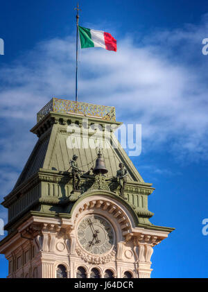 Die Uhr und Glockenturm in Triest mit der italienischen Flagge an der Spitze. Stockfoto