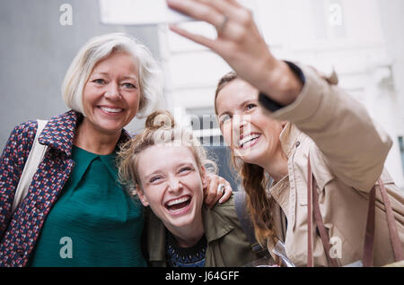 Lachen, Mutter und Töchter nehmen selfie Stockfoto