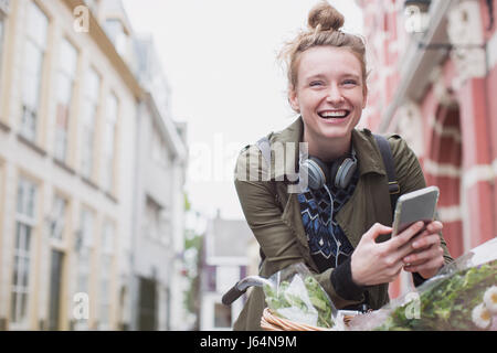 Porträt begeisterte junge Frau auf dem Fahrrad SMS auf Stadtstraße Stockfoto