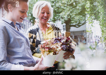 Florist Topfpflanzen an weibliche Käufer im Schaufenster zeigen Stockfoto