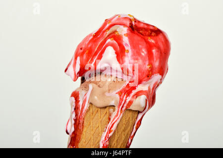 Nahaufnahme von einem schmelzenden Eis von verschiedenen Geschmacksrichtungen serviert in einem Kegel vor eine wollweiße Hintergrund Stockfoto