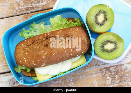 Gesunden Lunchpaket mit braunen Brötchen mit Käse und hart gekochtes Ei und Kiwi-Frucht Stockfoto