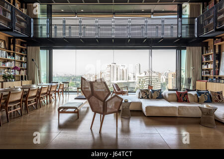 Doppelter Höhe Wohnzimmer mit Blick auf Beirut. Der fünfeckige geformte caned Sessel ist von Philippe Bestenheider und das modulare Sofa von Peir Stockfoto