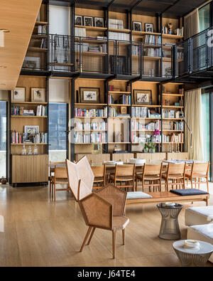 Doppelter Höhe Wohnzimmer mit fünfeckigen Form caned Sessel von Philippe Bestenheider. Der Esstisch wurde von Bernard Khoury entworfen und Stockfoto