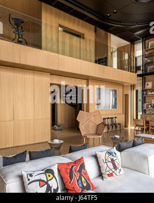 Doppelter Höhe Wohnzimmer mit fünfeckigen Form caned Sessel von Philippe Bestenheider und kombinierbares von Peiro Lissoni für Living Divani. Stockfoto