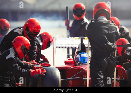 Boxencrew ersetzen Reifen auf Formel 1 Rennwagen in der Boxengasse Stockfoto