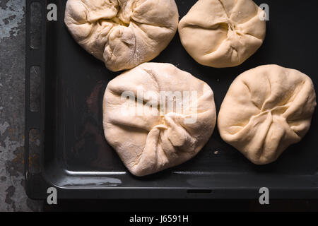 Khachapuri mit Käse auf ein Backblech auf einer metallischen Hintergrund-Nahaufnahme Stockfoto