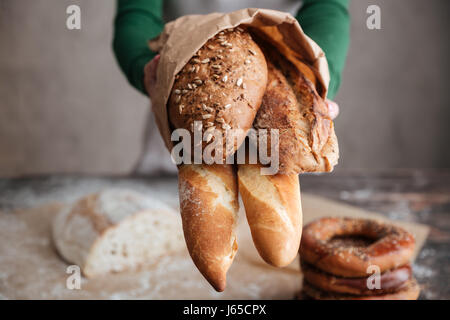 Bild einer weiblichen Baker zeigt Tasche mit Brot in die Kamera zugeschnitten. Nahaufnahme Foto Stockfoto