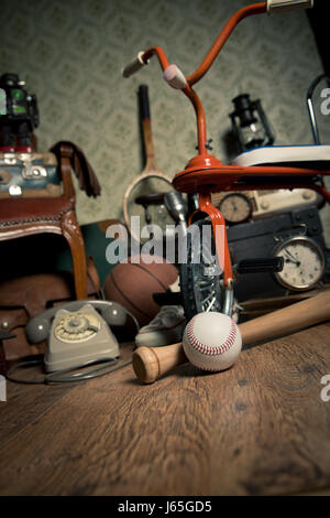 Gruppe von Vintage Objekte auf Hartholz Dachgeschoss, einschließlich der alten Spielzeug, Telefon und Sport Artikel. Stockfoto