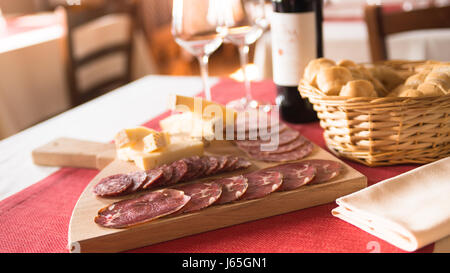 Leckere Vorspeisen am Restaurant, Salami und Käse auf einem Holzbrett mit Brot und Wein Stockfoto