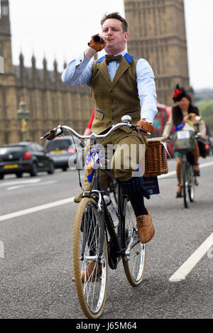 Tweed Run Radfahrer in London überqueren die Westminster Bridge und passieren die Houses of Parliament Stockfoto