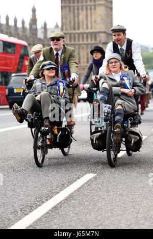 Tweed Run Radfahrer in London überqueren die Westminster Bridge und passieren die Houses of Parliament Stockfoto