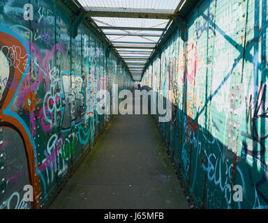 Mann zu Fuß entlang Graffiti bedeckt Fußgängerweg, Sheffield, South Yorkshire, England Stockfoto