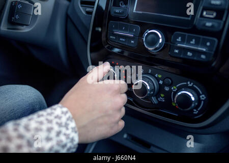 männliche Hand Drücken des Knopfes in modernen Autos. Man passt die Temperatur der Klimaanlage Auto Stockfoto