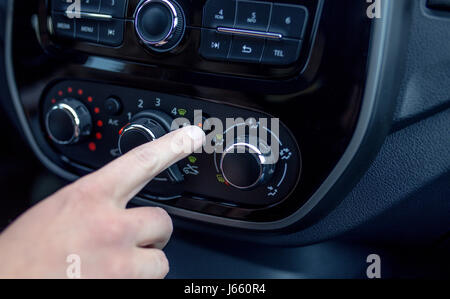 männliche Hand Drücken des Knopfes in modernen Autos. Man passt die Temperatur der Klimaanlage Auto Stockfoto