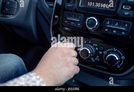 männliche Hand Drücken des Knopfes in modernen Autos. Man passt die Temperatur der Klimaanlage Auto Stockfoto