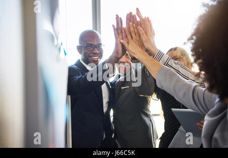 Gruppe von Geschäftsleuten hoch fünf positive suchen Stockfoto