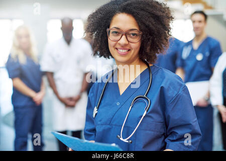 Hübsche junge afrikanische amerikanische Arzt stehen und blickte in die Kamera in einem Krankenhaus. Stockfoto
