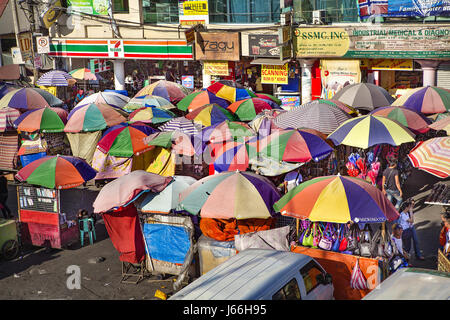 Bunte Sonnenschirme Schatten Käufern und Verkäufern in den Baclaran Freiluftmarkt in Manila, Philippinen. Stockfoto