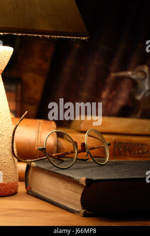 Vintage Stillleben mit der alten Brille Buch in der Nähe von Schreibtischlampe Stockfoto