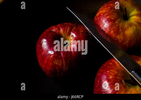 Reife rote Äpfel mit einem Messer Stockfoto