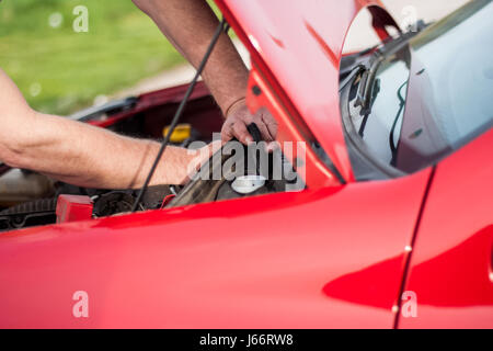 Hob die Motorhaube des Autos, das Auto blieb nicht in Ordnung, der Meister versucht, Fehlfunktion zu verweigern Stockfoto