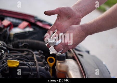 Meister beendet reparieren Autos, reine Hände, die beim Entfernen von Fehlfunktion schmutzig Stockfoto