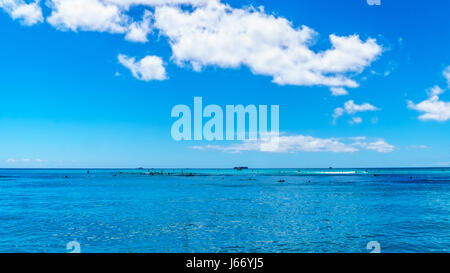 Das Wasser des Waikiki Beach in Honolulu auf der hawaiischen Insel Oahu unter blauem Himmel mit ein paar Quellwolken Stockfoto