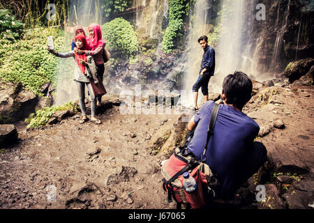 Kreative Bild, Indonesier, die Einnahme von Selfies am Jumog Wasserfall in Java, Indonesien. Atemberaubende Kulisse eines Wasserfalls aufgenommen mit Langzeitbelichtung Technik Stockfoto