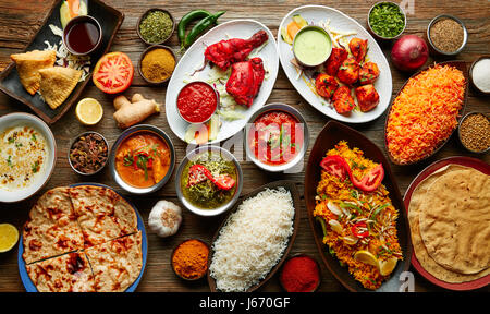 Verschiedene indische Rezepte Essen verschiedene mit Gewürzen und Reis auf Holztisch Stockfoto