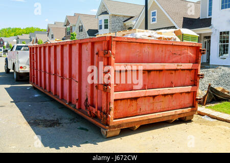 Mülltonnen in der Nähe von neue Zuhause, rote Container, recycling und Entsorgung. Baustelle im Hintergrund Stockfoto