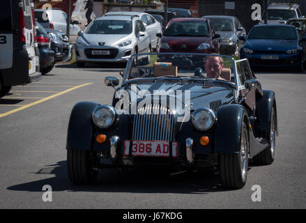 Morgan Motor Cars werden noch in Malvern, England hergestellt, wie sie im frühen 20. Jahrhundert waren. Ein Testfahrer in einem Plus vier Morgan verlässt das Werk. Stockfoto