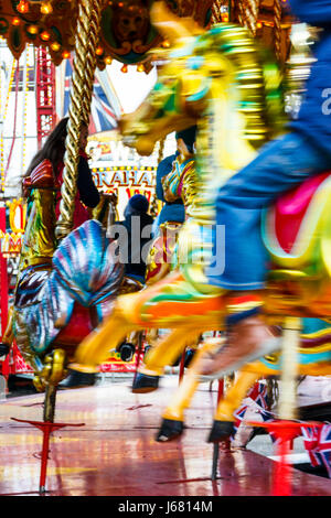 Bewegung - verschwommenes Bild von sich bewegenden Pferden auf einem traditionellen Karussell an eine Kirmes, London, UK Stockfoto