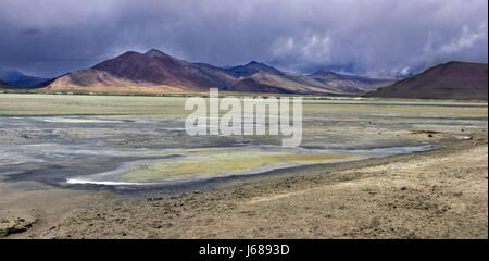 Sonnenuntergang in einem Gewitter in den hohen Bergen des Tals von Tso Kar: stark bewölkt, braunen Berge und wunderschöne gelbe und violette Erde, Ladakh, Stockfoto
