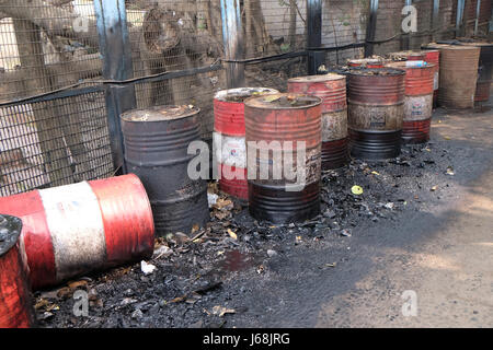 Alten rostigen Fass links in die Straße undichte dicker schwarzer Teer oder Öl auf einer städtischen Straße in Kolkata, Indien am 10. Februar 20 Stockfoto