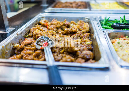 Nahaufnahme des Kung Pao Backhendl mit Sauce Buffet mit Löffel Stockfoto