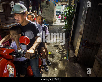 Bangkok, Bangkok, Thailand. 16. Mai 2017. LEK, ein Gemeindevorsteher in Pom Mahakan bringt einige der gemeinschaftlichen Kinder zu Hause von seiner Schule auf seinem Motorrad. Die endgültige Vertreibung der verbliebenen Familien in Pom Mahakan, ein Slum-Gemeinschaft in einem 19. Jahrhundert Fort in Bangkok, haben begonnen. Vertreter der Stadt ziehen die Bewohner aus der Festung. NGOs und Denkmalpflege Organisationen protestierten die Stadt Aktion aber städtischen Beamten nicht nachgeben und vertreiben die restlichen Familien Anfang März begonnen. Bildnachweis: Jack Kurtz/ZUMA Draht/Alamy Live-Nachrichten Stockfoto