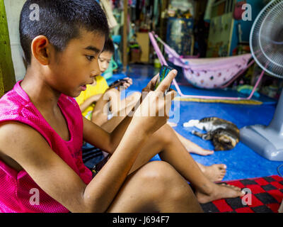 Bangkok, Bangkok, Thailand. 20. Mai 2017. Jungen spielen Videospiele auf ihren Smartphones in einem Heim in Pom Mahakan. Die endgültige Vertreibung der verbliebenen Familien in Pom Mahakan, ein Slum-Gemeinschaft in einem 19. Jahrhundert Fort in Bangkok, haben begonnen. Vertreter der Stadt ziehen die Bewohner aus der Festung. NGOs und Denkmalpflege Organisationen protestierten die Stadt Aktion aber städtischen Beamten nicht nachgeben und vertreiben die restlichen Familien Anfang März begonnen. Bildnachweis: Jack Kurtz/ZUMA Draht/Alamy Live-Nachrichten Stockfoto