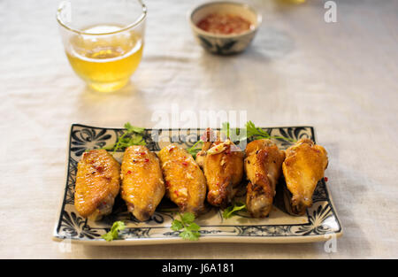 Gebratene Hähnchenflügel mit Salat und Fischsauce Stockfoto