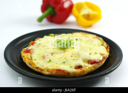 Hähnchen Pizza im koreanischen Stil mit Paprika auf schwarzem Teller Stockfoto