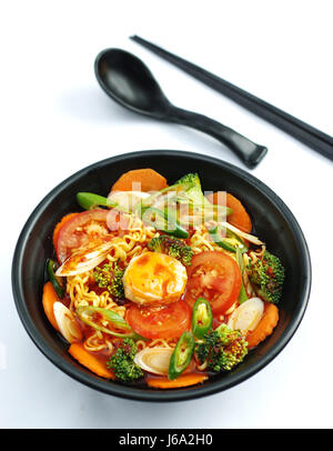 Hot Chili Ramen-Nudeln mit Tofu und Tomaten in schwarz Eintopf Stockfoto