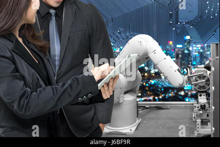 Industrie 4.0 Internet der Dinge-Konzept. Zwei Ingenieure und Finger weisen auf eine Tablette für die Überwachung der Automatisierung wireless Robot Maschine Arm Hintergrund in s Stockfoto