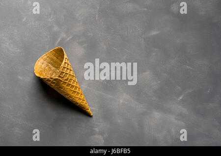 Leere knusprige Eiswaffel auf Zement-Hintergrund Stockfoto
