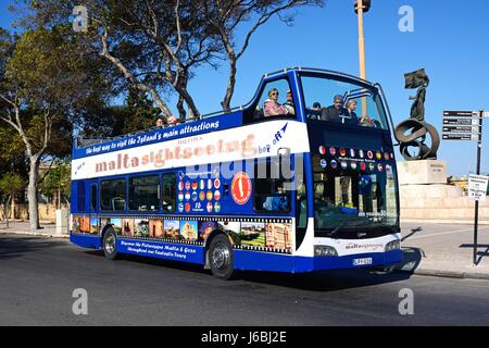 Passagiere an Bord eines Busses öffnen gekrönt Tourbus mit dem Unabhängigkeits-Denkmal an der Rückseite, Floriana, Malta, Europa. Stockfoto