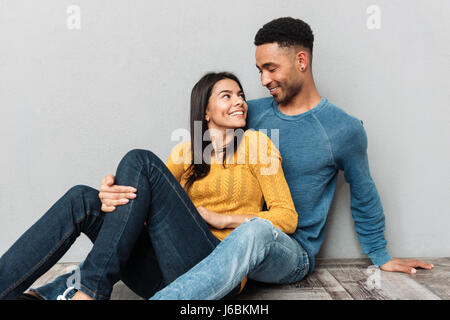 Hübsche Frau und afrikanischen gut aussehender Mann sahen einander am Boden Stockfoto