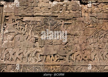 Stein-Flachrelief einer Kampf-Szene an der außen Wand des Bayon Tempel in Angkor Wat Komplex. Dieses reich geschnitzte Stein "ist Teil eines großen Wandbildes Stockfoto